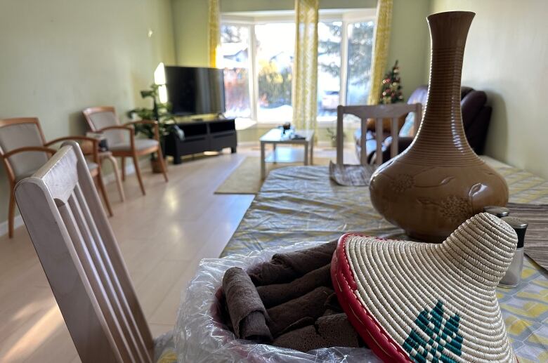 A wicker basket sits on a table with a living room in the background. 