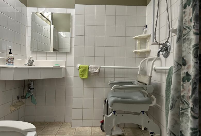 A washroom with a personal assistance chair in the no-step shower.