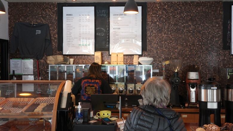 A Java Blend worker dispenses coffee beans at the cafe's North St. location on Wednesday.