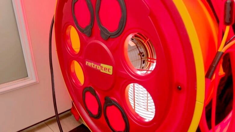 A red fan is shown inside of a door at the entrance of a house.