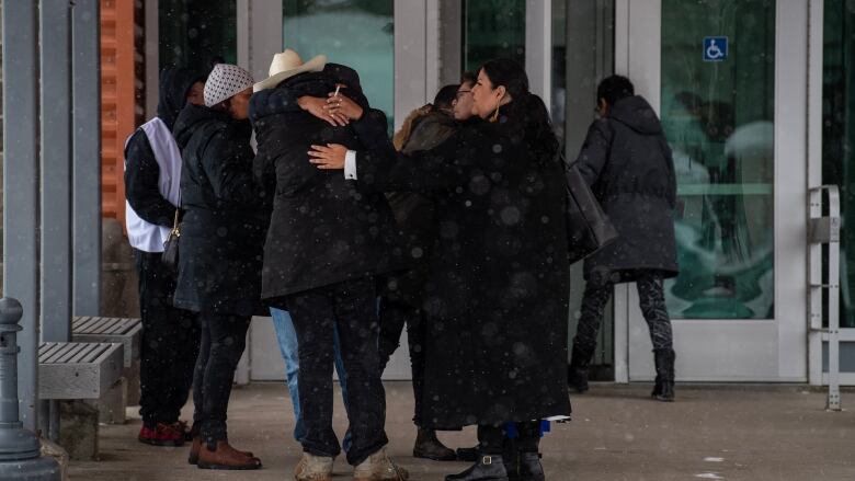 People are seeing hugging outside a recreation centre.