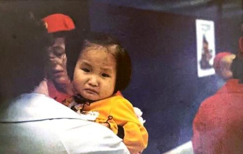 A child being carried at an airport.