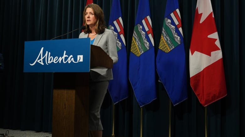 A woman stands behind a podium.