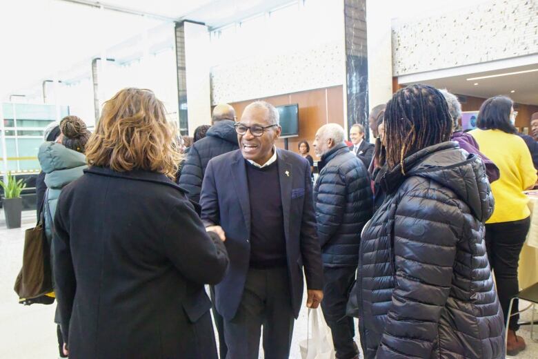 A man shakes people's hands.