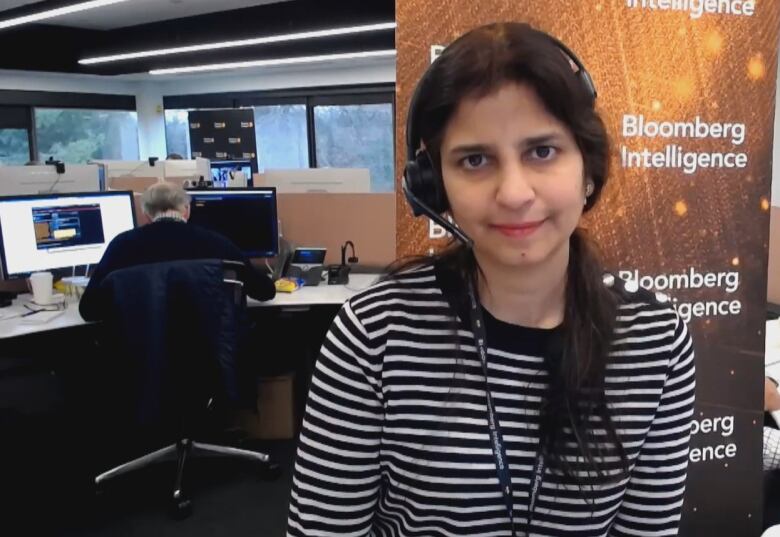 A woman is pictured in front of a Bloomberg Intelligence sign.