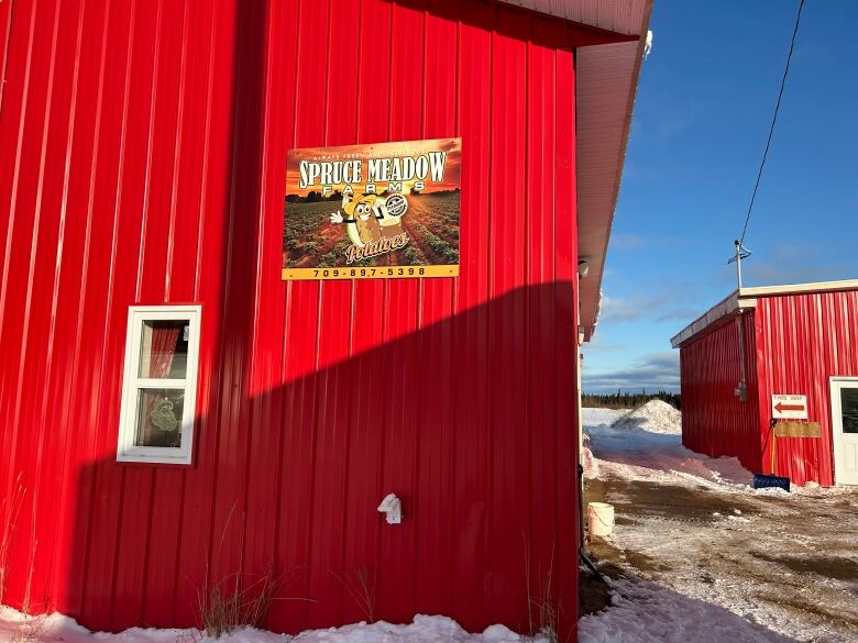 a red building with a sign on it saying Spruce Meadow Farm