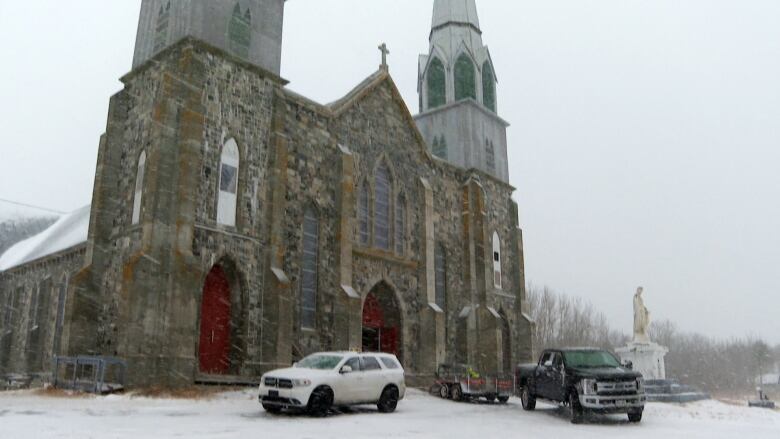 A large stone church on a snowy day.