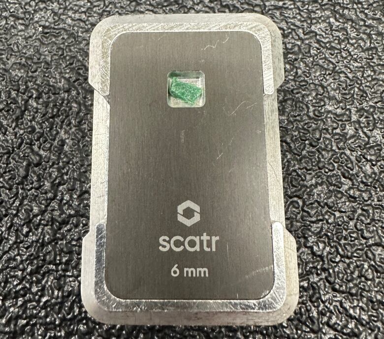 A green crystal in a black card reader.