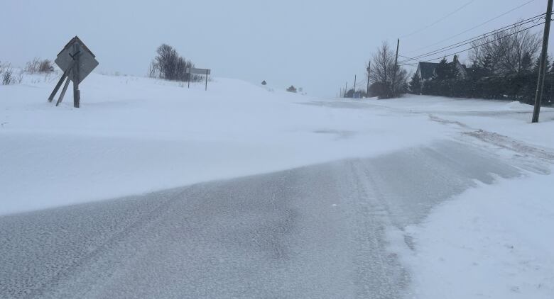 A highway with deep snow drifts across it.