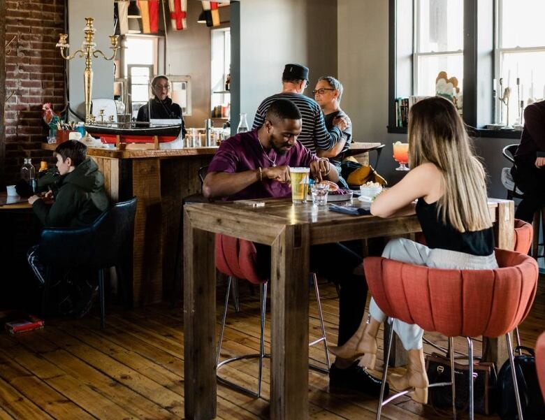 A couple eating at a table in a rustic bar 