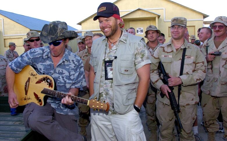 Several soldiers are shown with two musicians.