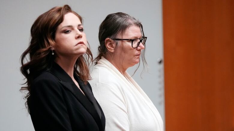 Jennifer Crumbley, wearing a white top and glasses, and her attorney Shannon Smith stand in court.