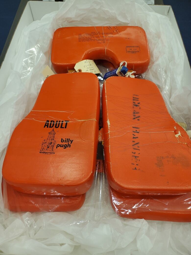 An orange life jacket inside of a box. 