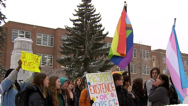 Students holding flags outside in the snow. 