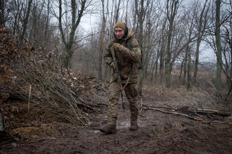 A Ukrainian soldier walks along a position near the front line in the Kreminna area in Ukraine's Luhansk region.