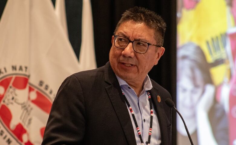 A man speaks into a microphone at a podium. 