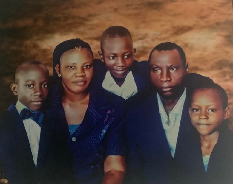 A family portrait of a Black family wearing blue outfits.