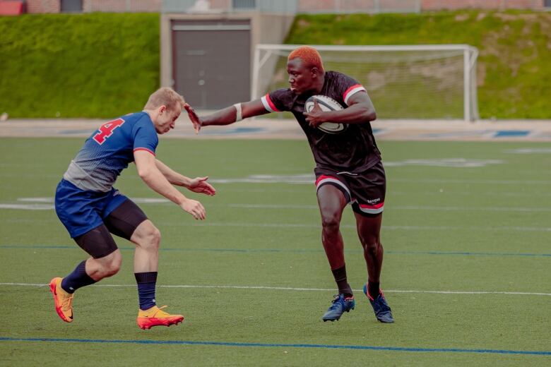 Two rugby players on a field.