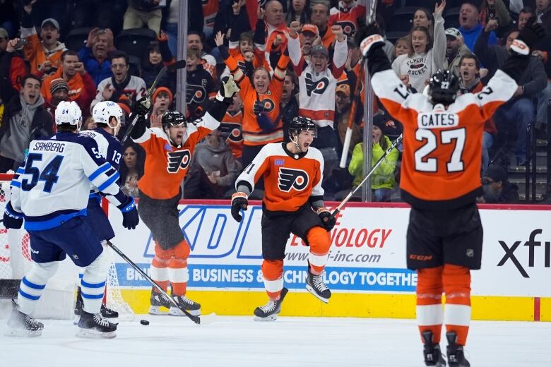 Three hockey players cheering on the ice.