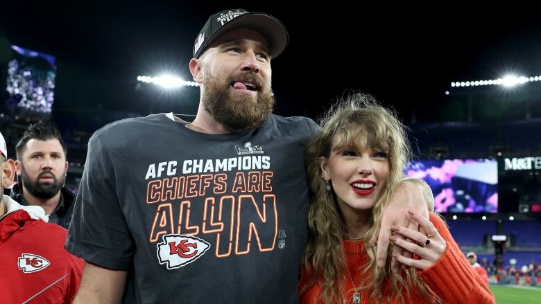 Men's football player celebrates with women's pop star following football game. 