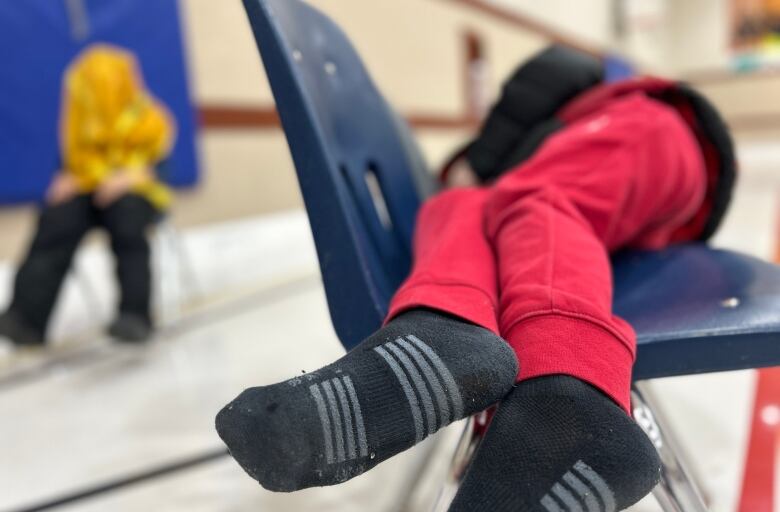 A child sleeping on some chairs.