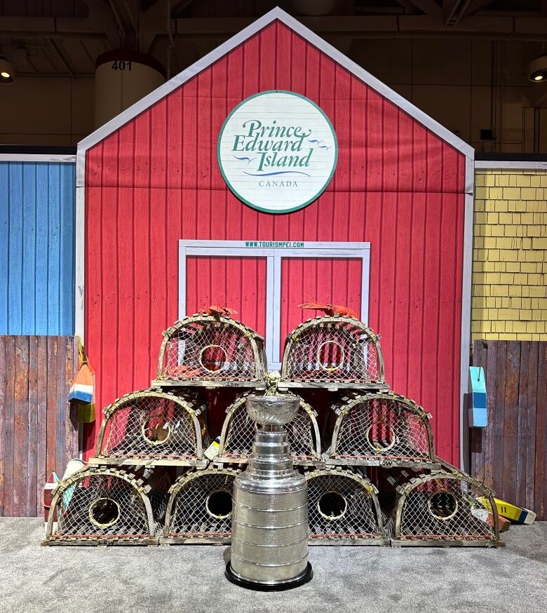 A P.E.I. tourism booth depicting a red barn with lobster traps in front and the Stanley Cup in the foreground.