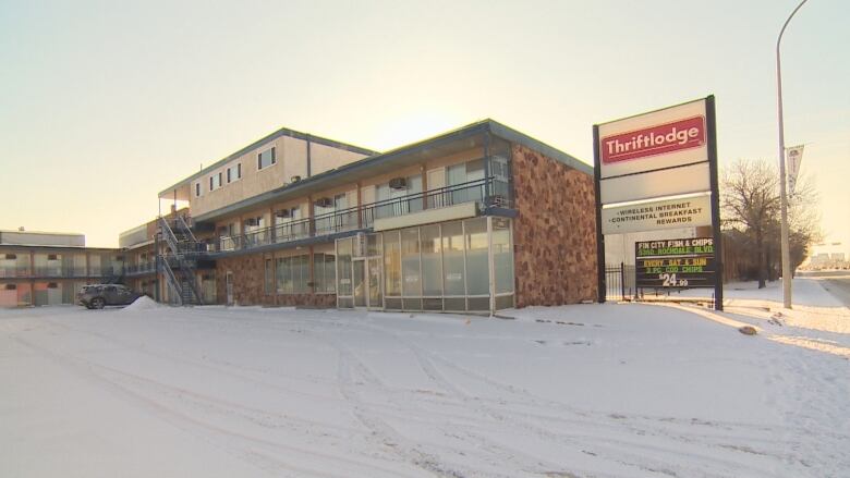 A brick motel building with a sign next to it that reads 