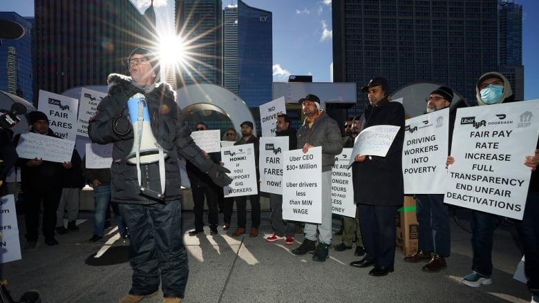 Man with megaphone speaks to protesters.