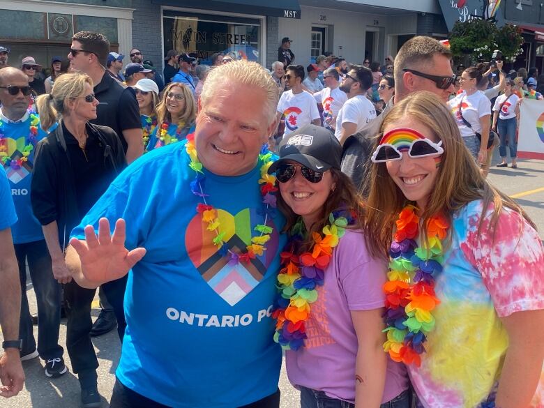 A man in a Pride T-shirt poses for a photo.