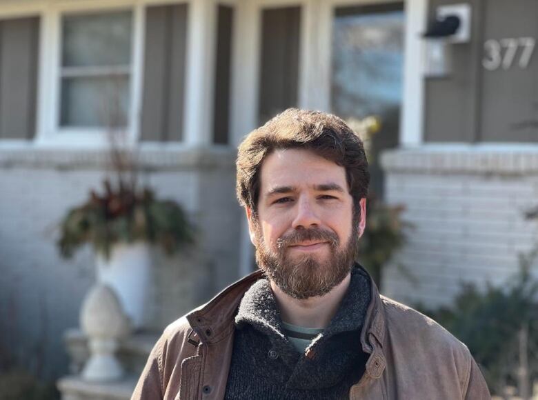 Bruce Moras, 34, stands in front of his parents house, where he lives. 