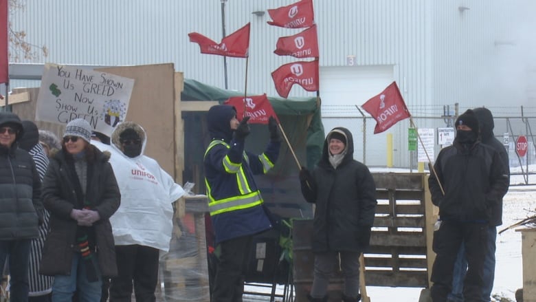 Striking workers on a picket line during winter weather.