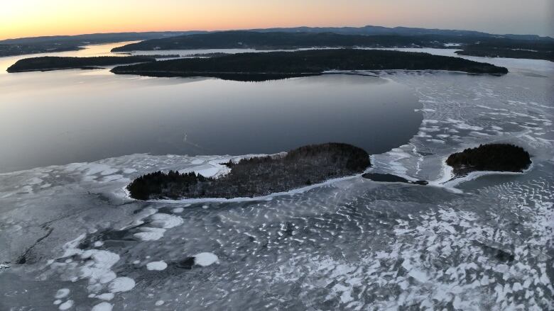 An icy river, photographed from the sky. There are small islands dotting the river.