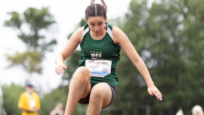 A girl in team PEI uniform leaping through the air