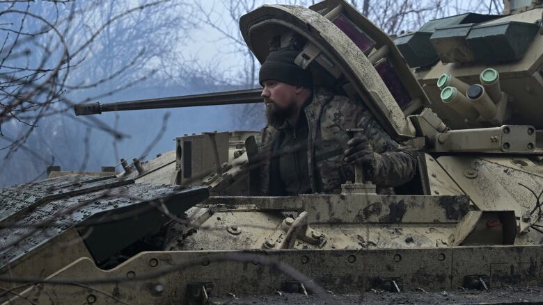 A soldier is seen operating a tank.