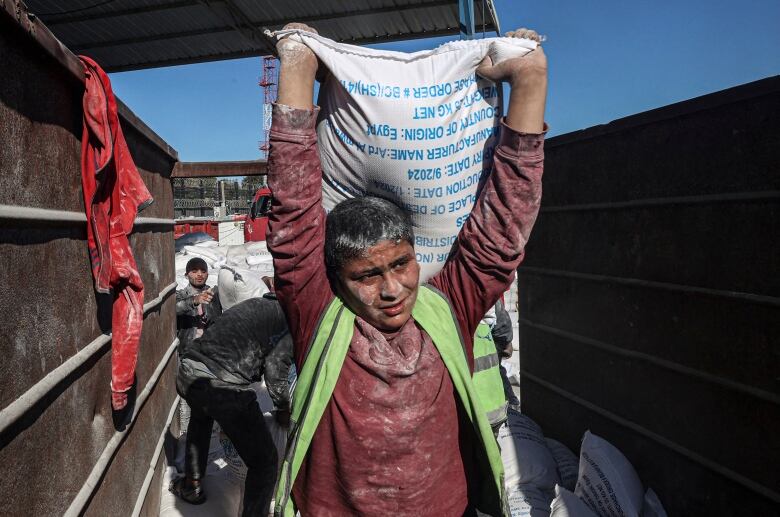 Workers unload bags of humanitarian aid.