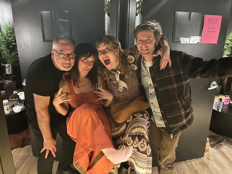 Two men and two women are shown backstage at a Feist concert.