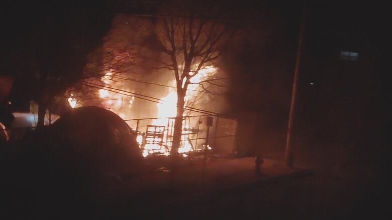 A still from a video shows a tent fully engulfed by flames. 