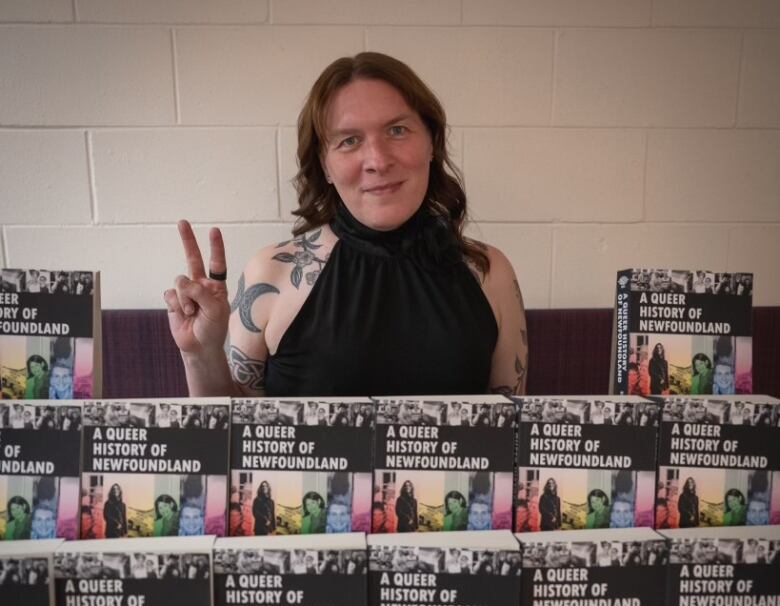 A woman stands in front of a display of books.