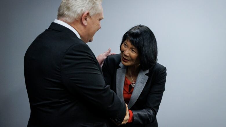 A man and a woman shake hands.