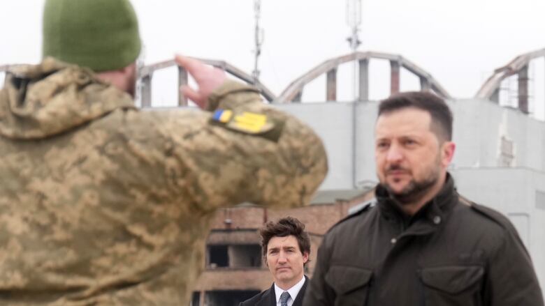 Soldier salutes Ukrainian President Volodymyr Zelenskyy and Canadian Prime Minister Justin Trudeau.