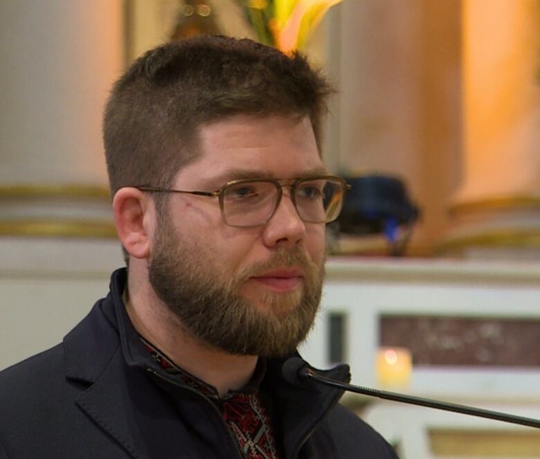 A man stands behind a microphone.