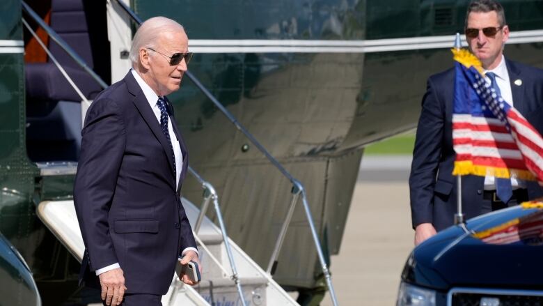 U.S. President Joe Biden walks toward a car. 