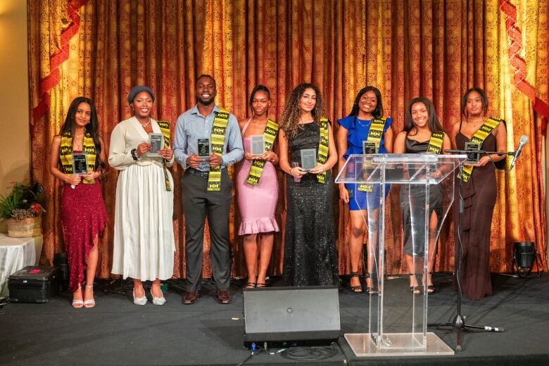 People standing holding awards on a stage.