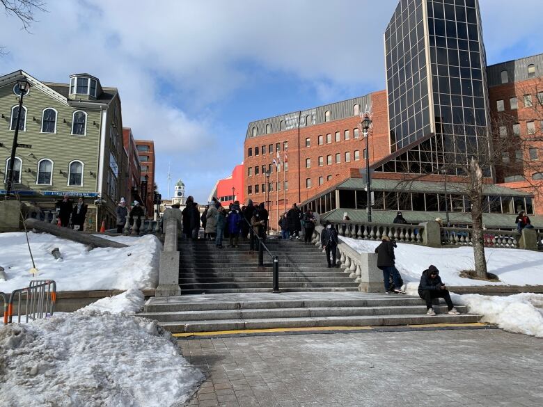 A few people stand on the steps of Grand Parade in Halifax on Monday, Feb. 26.