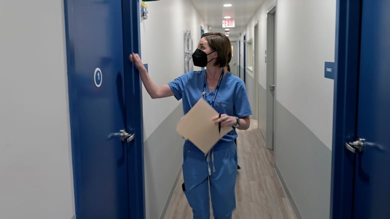 A doctor enters an exam room consult with a patient.