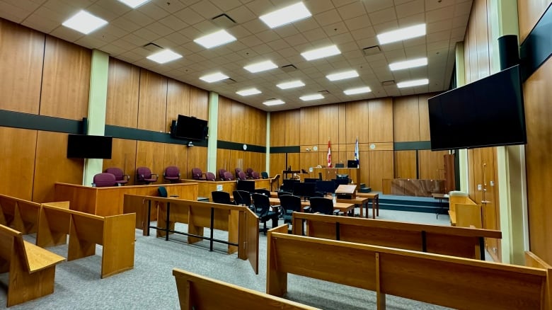 An empty courtroom with wood-paneled walls.