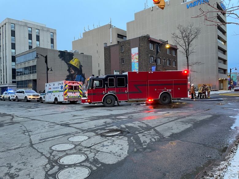 A fire truck and ambulance blocking a downtown street.