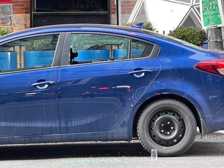 Blue car's rear window shattered.