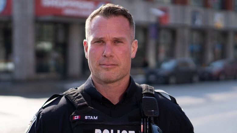 A police officer poses outside.