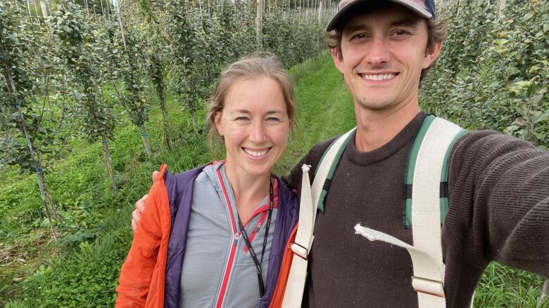 Coady and Jaeson Waygood hold a basket of apples at their orchard near Fredericton.